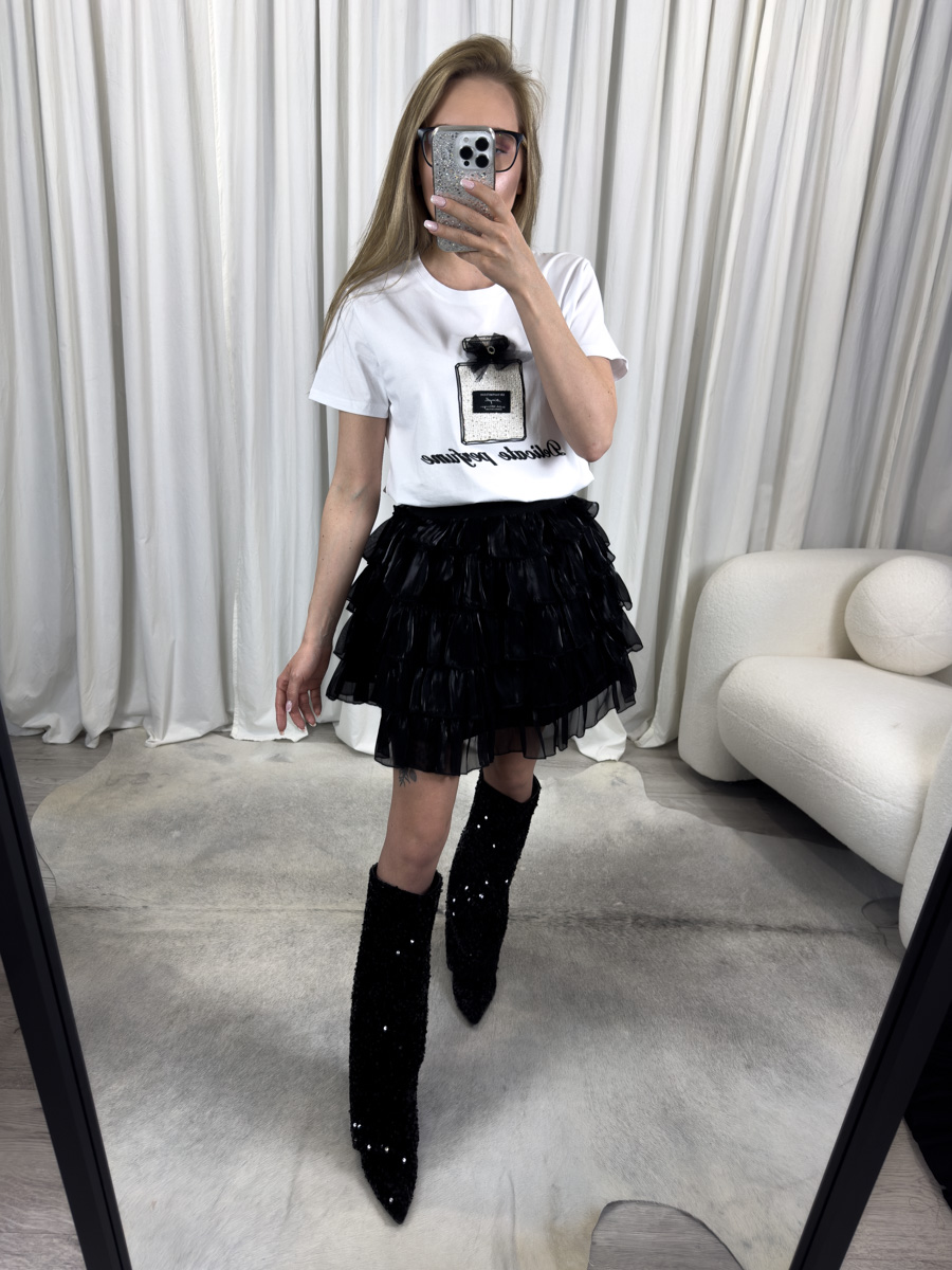 T-shirt Perfume biały z aplikacją flakonika perfum i kokardką 3D, zestawiony z czarną mini spódnicą z falbanami i cekinowymi kozakami – stylizacja z modowym akcentem.