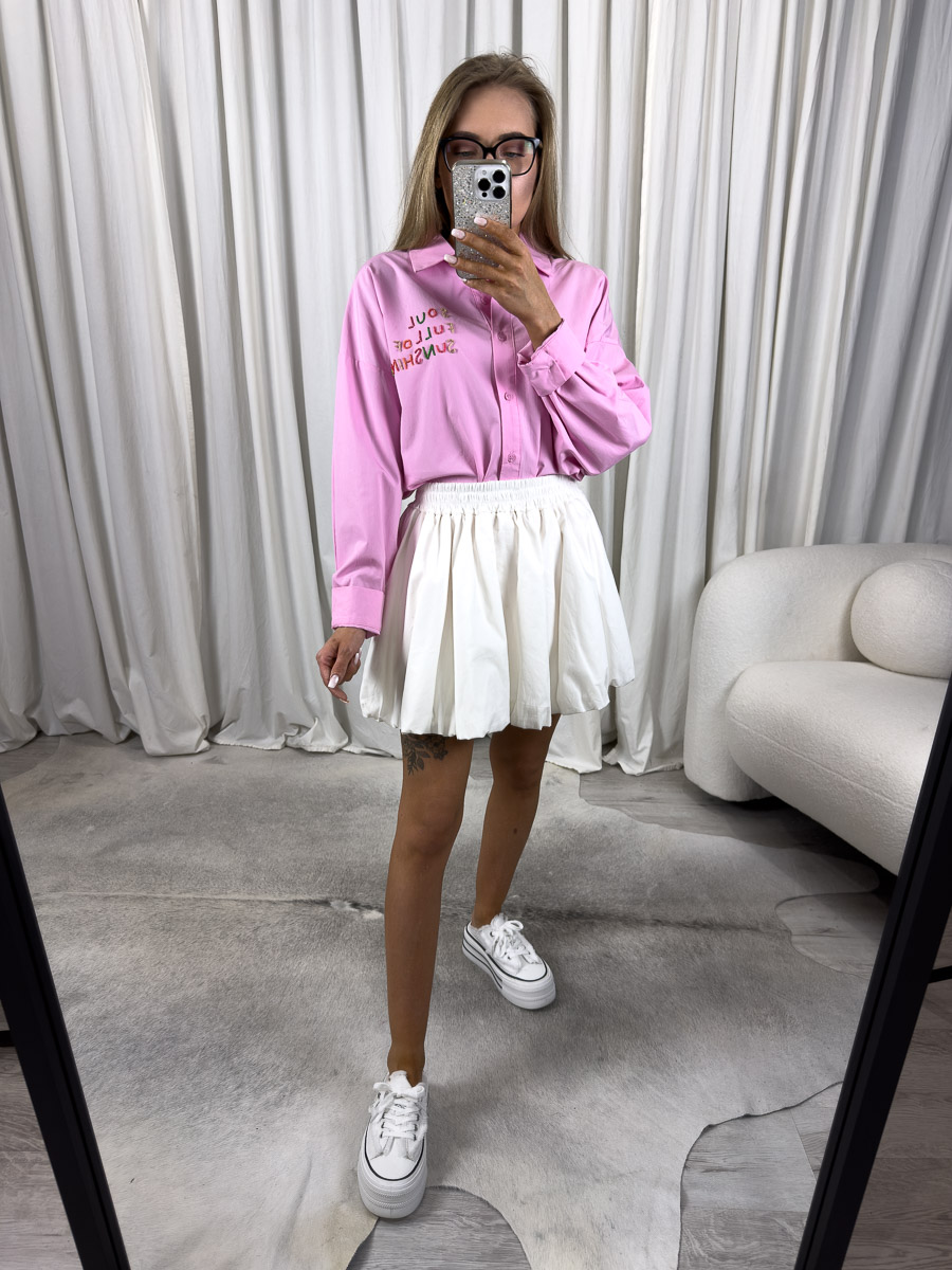 Zdjęcie produktowe sklepu internetowego z odzieżą damską – modelka ubrana w koszule popelinową Sunshine w kolorze różowym marki Wiya, spódnico-spodenki w kolorze białym oraz białe trampki