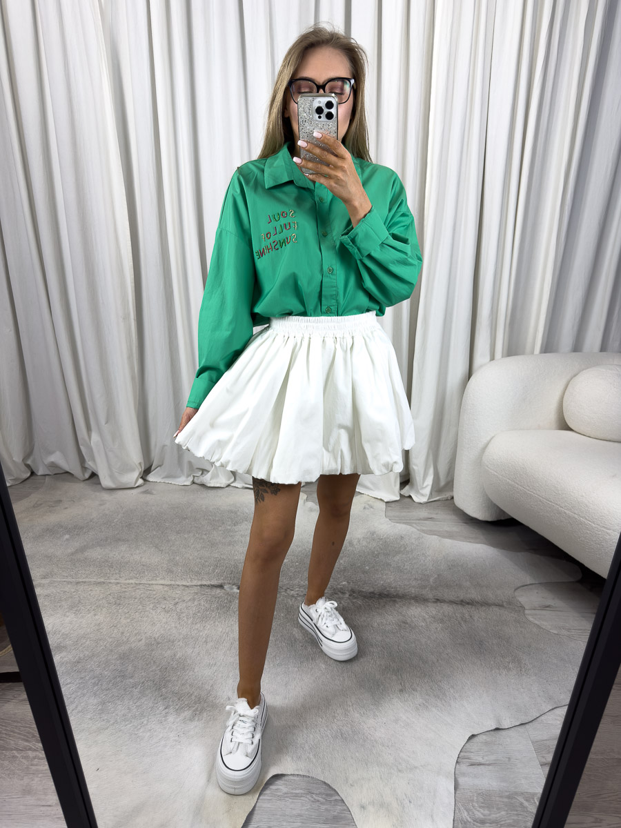 Zdjęcie produktowe sklepu internetowego z odzieżą damską – modelka ubrana w koszule popelinową Sunshine w kolorze zielonym marki Wiya, spódnico-spodenki w kolorze białym oraz białe trampki