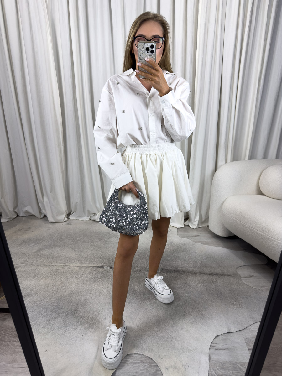 Zdjęcie produktowe sklepu internetowego z odzieżą damską – modelka ubrana w koszule popelinową Viven w kolorze białym, spódnico-spodenki w kolorze białym oraz białe trampki