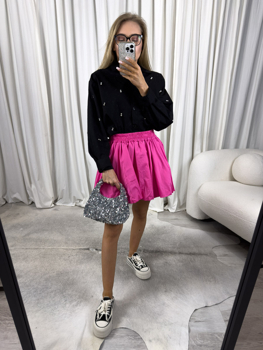 Zdjęcie produktowe sklepu internetowego z odzieżą damską – modelka ubrana w koszule popelinową Viven w kolorze czarnym, spódnico-spodenki w kolorze fuksji oraz ciemne trampki