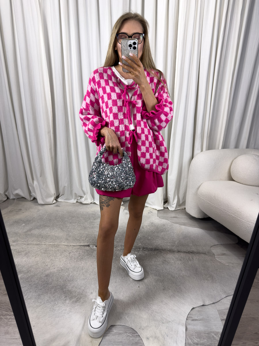 Zdjęcie produktowe sklepu internetowego z odzieżą damską – modelka w trampkach ubrana w kardigan Naomi różowy w print szachownicy i krótkie spódnico-spodnie