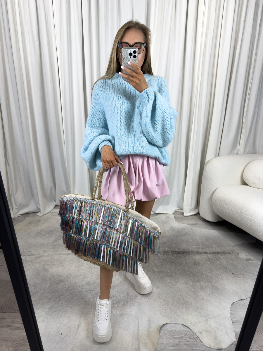 Kobieta ubrana w sweter oversize w kolorze babyblue, różowymi szortami, plażową torebką - letnia stylizacja.