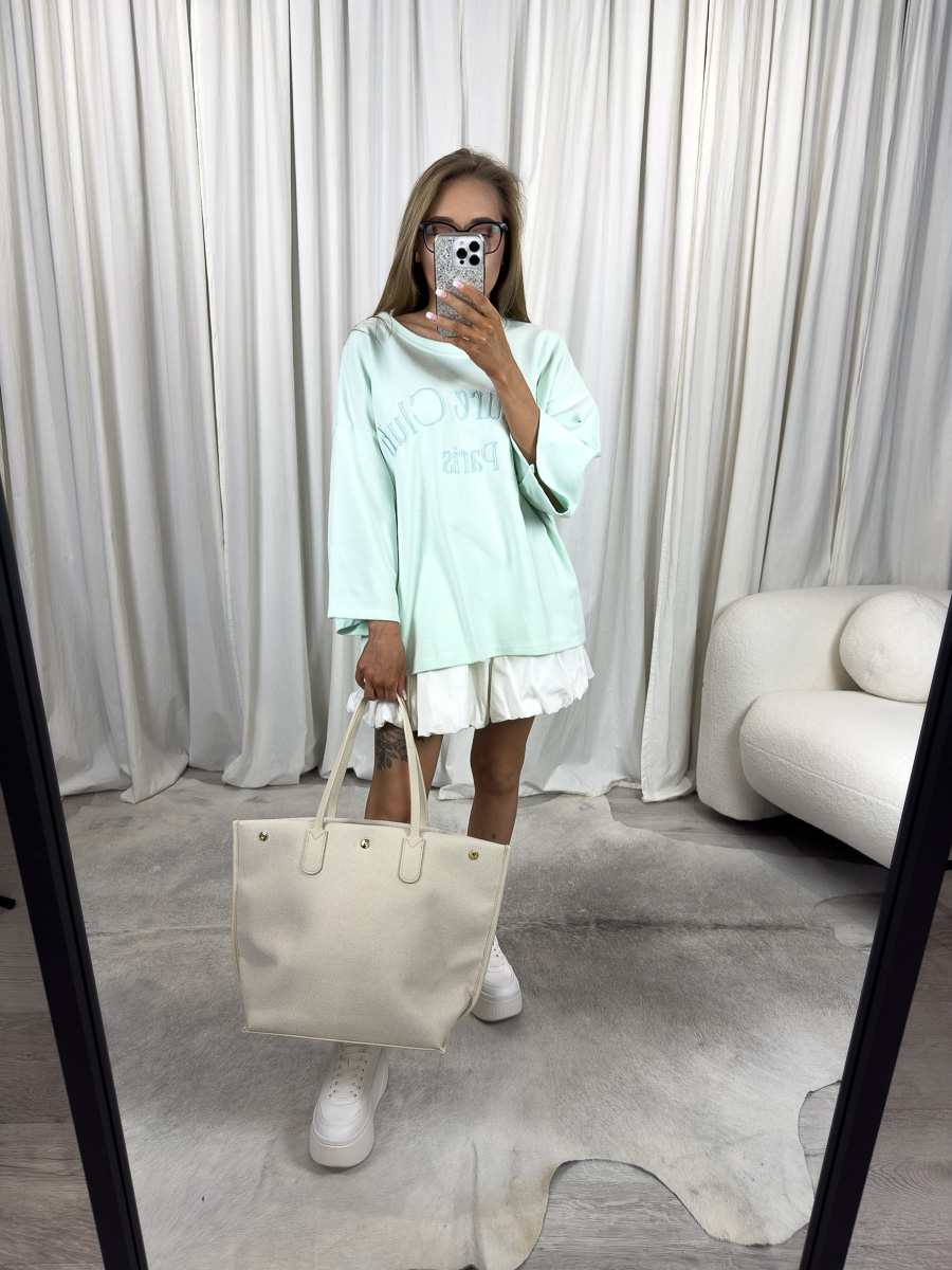 Lekka bluza oversize Club miętowa – pastelowa bluza oversize z haftem „Club Paris”, stylizacja z białą spódniczką i kremową torbą.