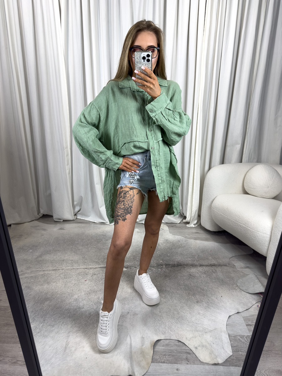 Zielona lniana koszula Lori Wiya - asymetryczny krój oversize, naturalny len i luźny fason. Stylizacja z niebieskimi, jeansowymi szortami.