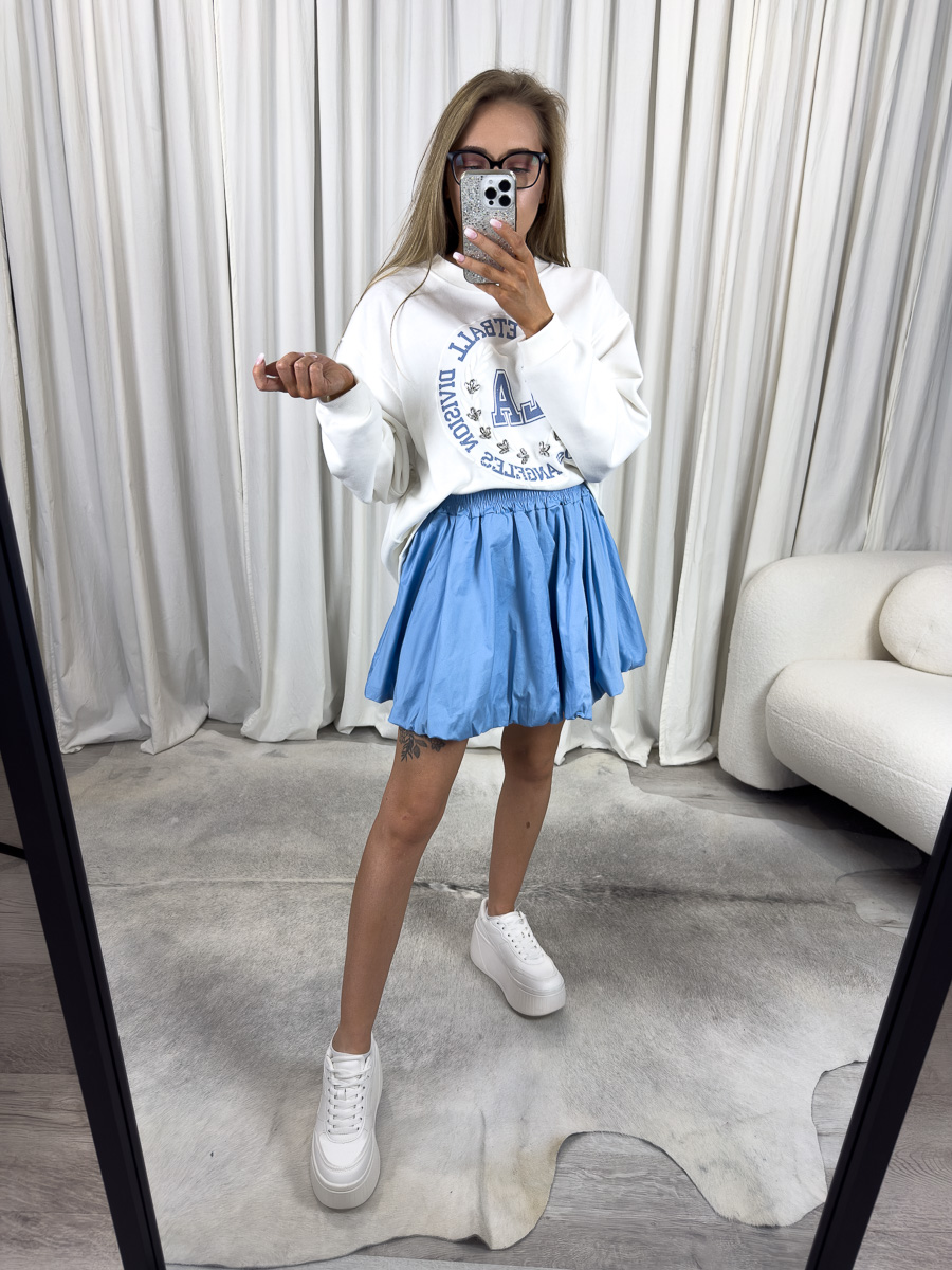 Modelka w błękitnej mini spódnicy z popeliny Cutie o balonowym kroju i elastycznym pasie – stylizacja z bluzą oversize i sneakersami, zdjęcie produktowe na potrzeby sklepu internetowego.