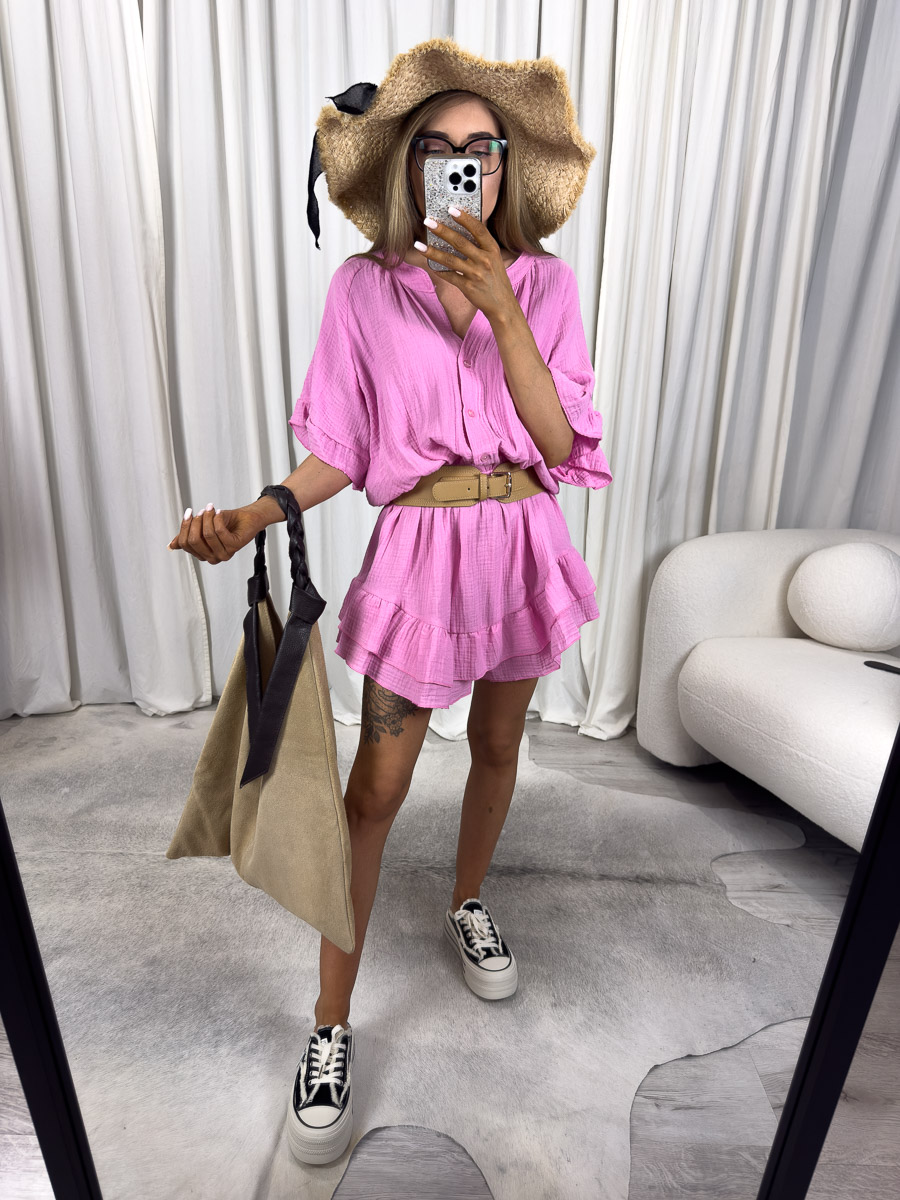 Modelka w kombinezonie muślinowym Soho z falbanami, elastycznym pasem i rozpinanym dekoltem, w stylizacji z kapeluszem i torbą. Zdjęcie produktowego sklepu internetowego z odzieżą damską.