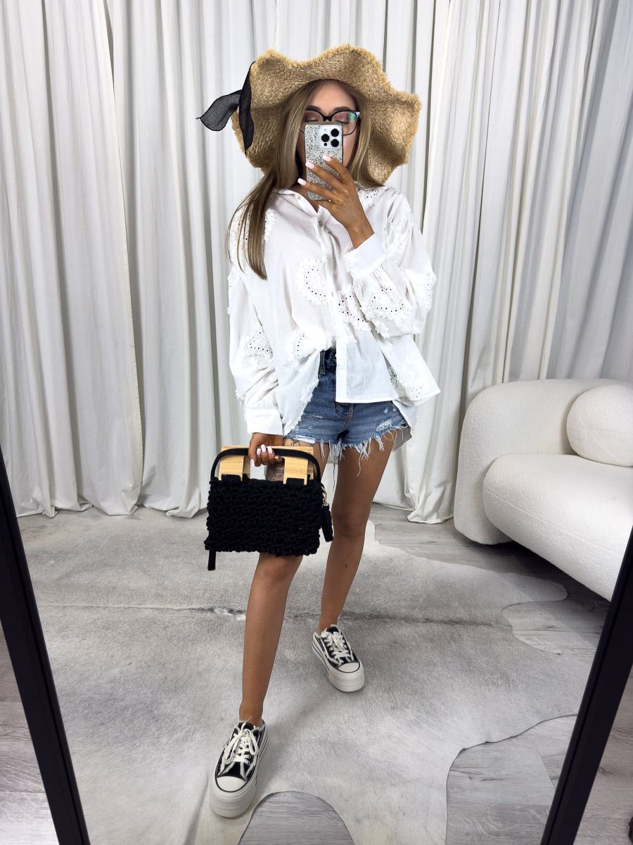 Zdjęcie produktowe sklepu internetowego z odzieżą damską – modelka w koszuli boho Sunray Gioya z haftem angielskim, letnia stylizacja z kapeluszem i szortami.