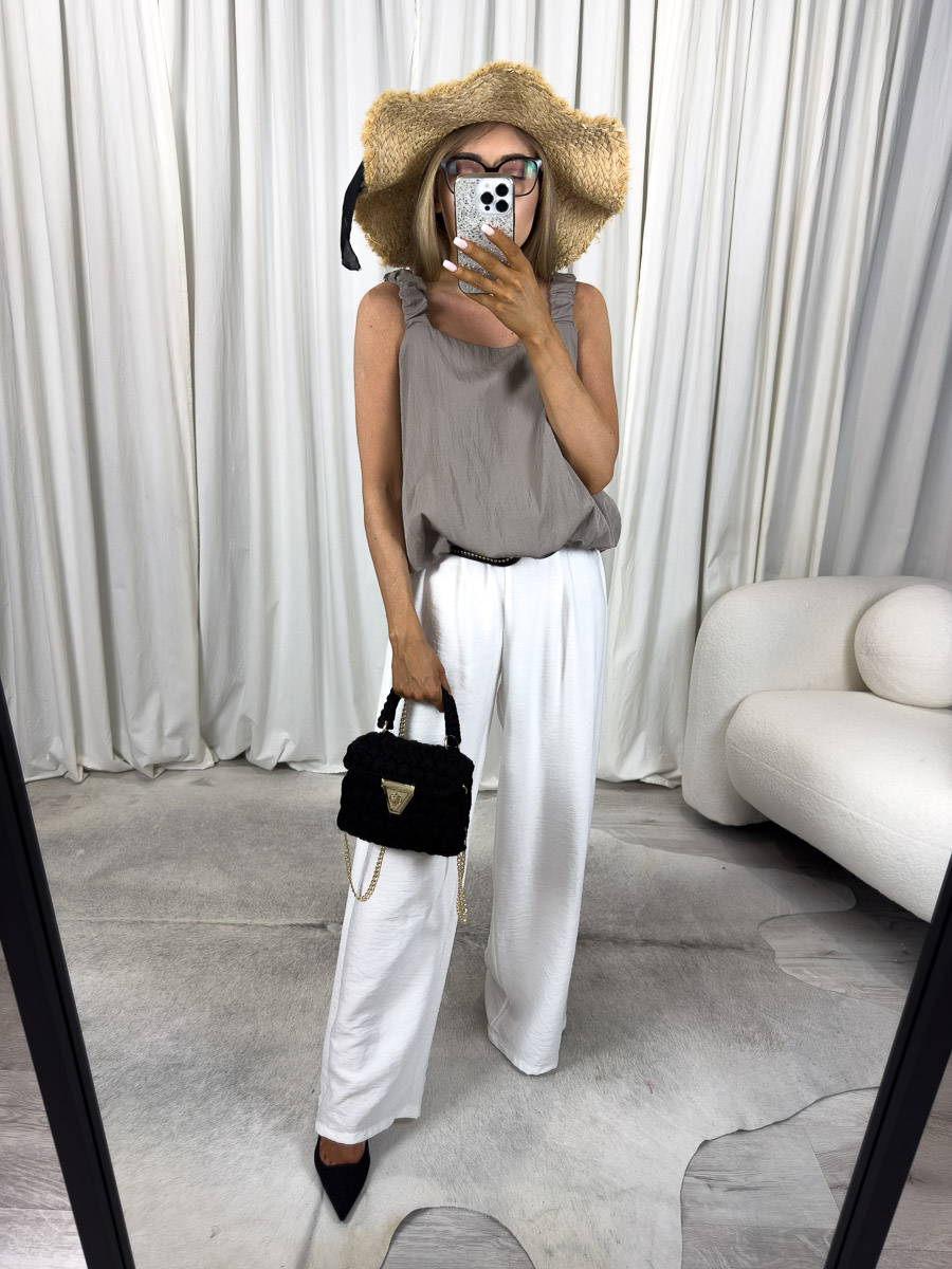 Letnie spodnie June – szerokie spodnie z wysokim stanem na lato, stylizacja z kapeluszem i torebką, zdjęcie na jasnym tle. Zdjęcie produktowe sklepu internetowego z odzieżą damską.