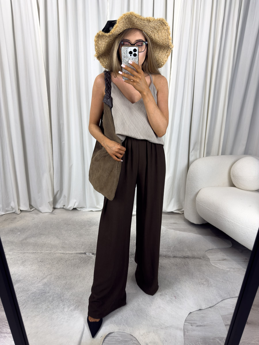 Letnie spodnie June – szerokie spodnie z wysokim stanem na lato, stylizacja z kapeluszem i torebką, zdjęcie na jasnym tle. Zdjęcie produktowe sklepu internetowego z odzieżą damską.