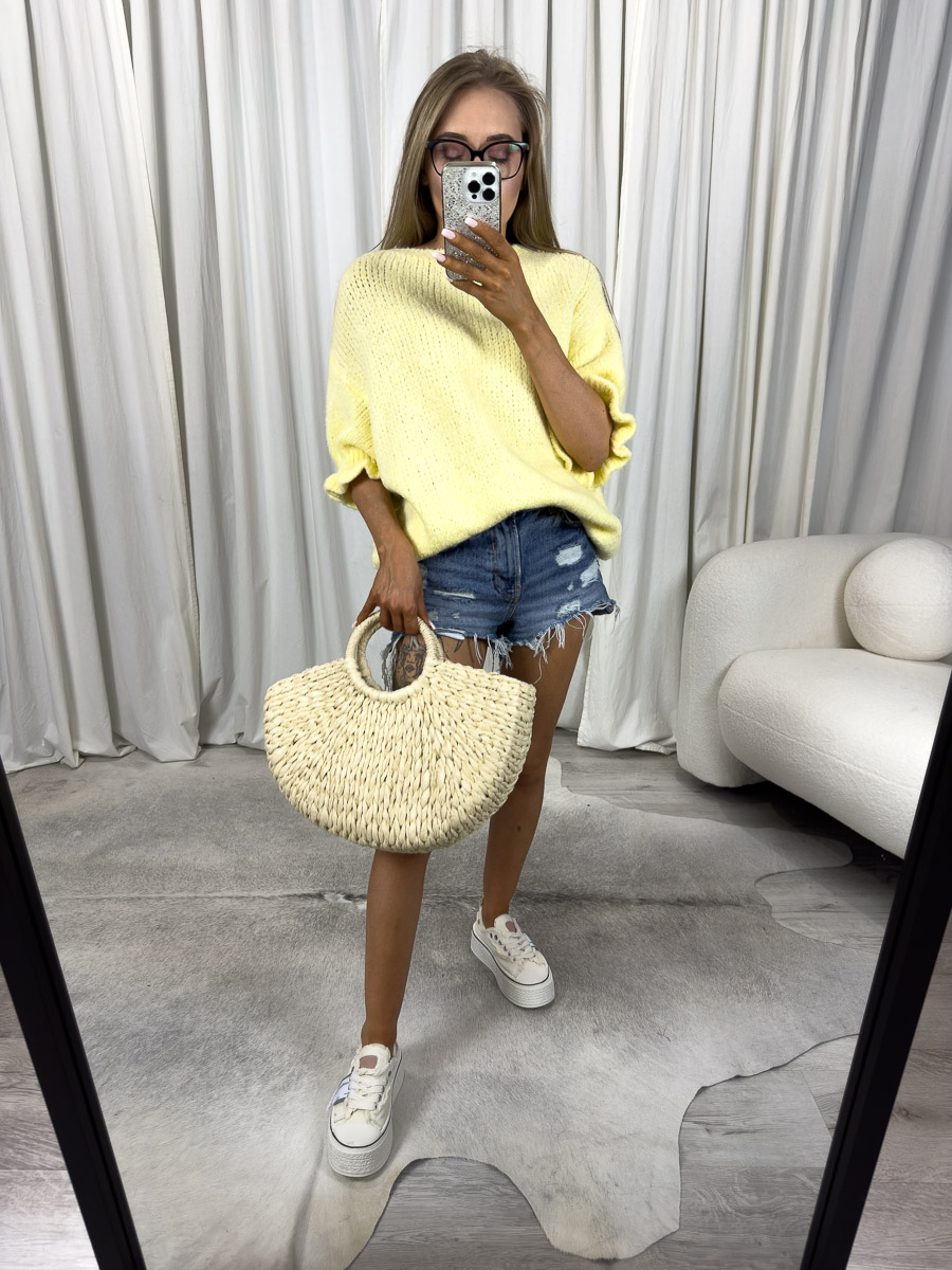 Modelka w żółtym swetrze pastelowym Flounce, jeansowych szortach i białych trampkach.