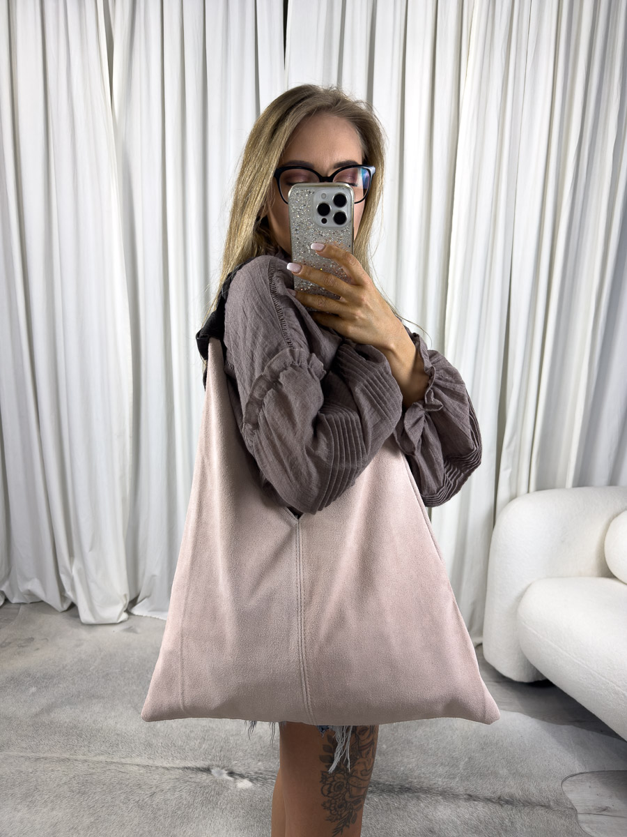 Modelka trzymająca zamszową torebkę Africa w kolorze pudrowego różu. Zdjęcie produktowe sklepu internetowego z odzieżą damską.